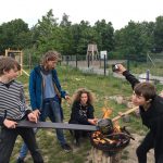 Die Sipplinge der Sippe Manul machen ein Lagerfeuer und posen lustig darum für das Foto.